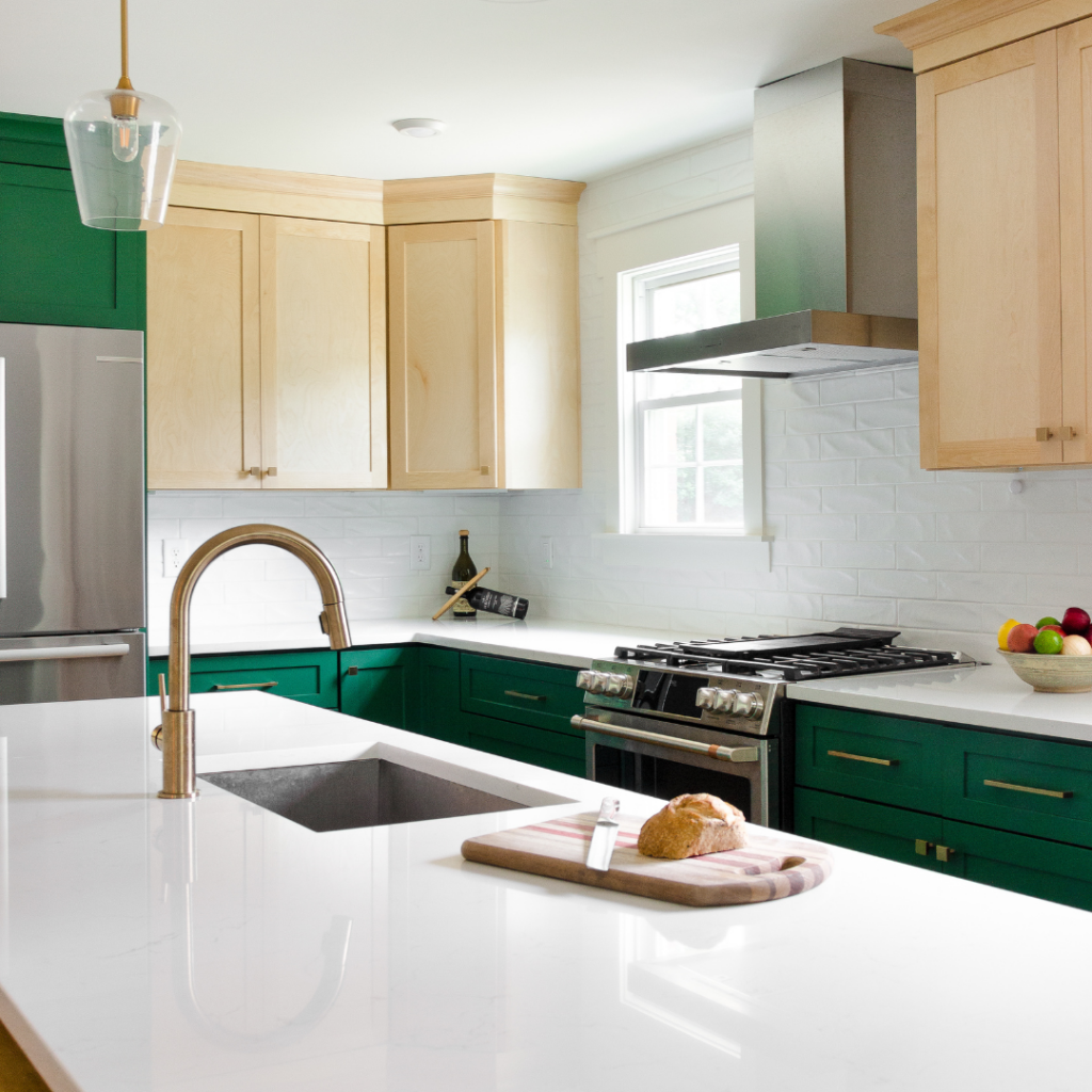 Modern kitchen remodel with green lower cabinets, natural wood upper cabinets, and a large island.
