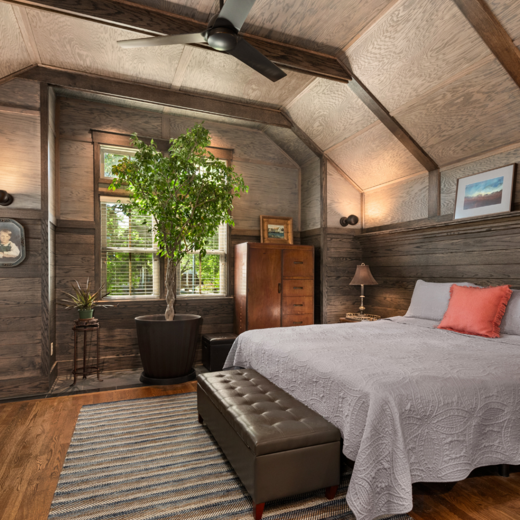 Rustic bedroom renovation with exposed wood beams and warm lighting.