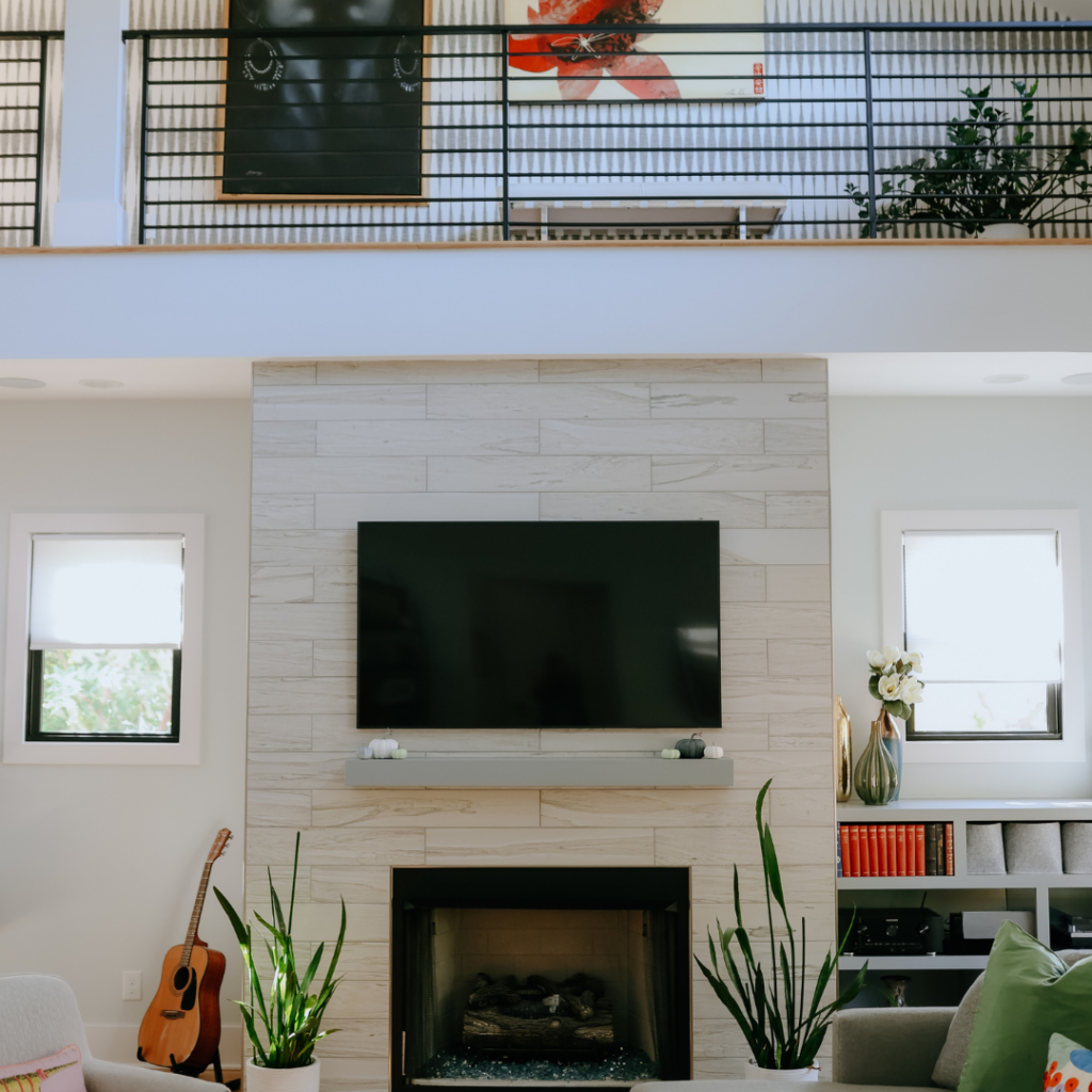 Contemporary living room renovation with a fireplace and loft space.