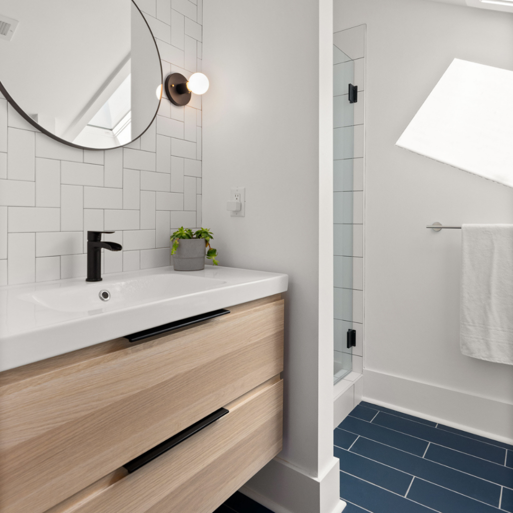 Sleek modern bathroom with floating vanity, black fixtures, and geometric tile design.