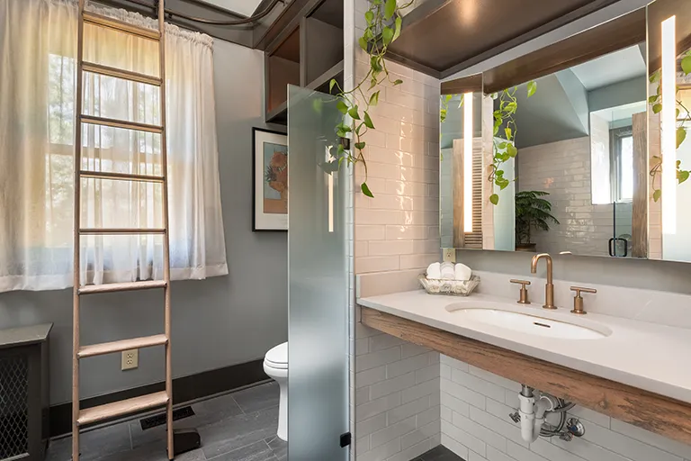 modern bathroom remodel in Nashville with white tile and brass fixtures