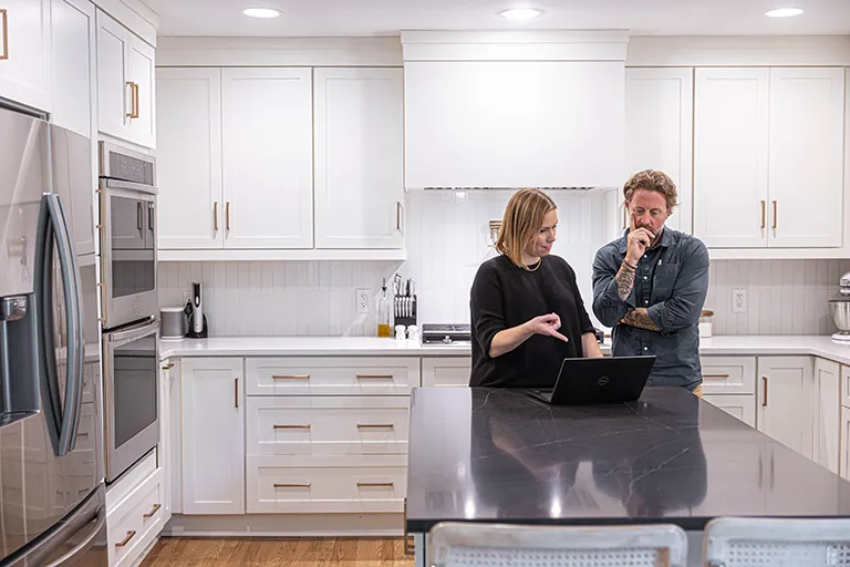 Design-build contractor collaborates with client in white kitchen with gray island