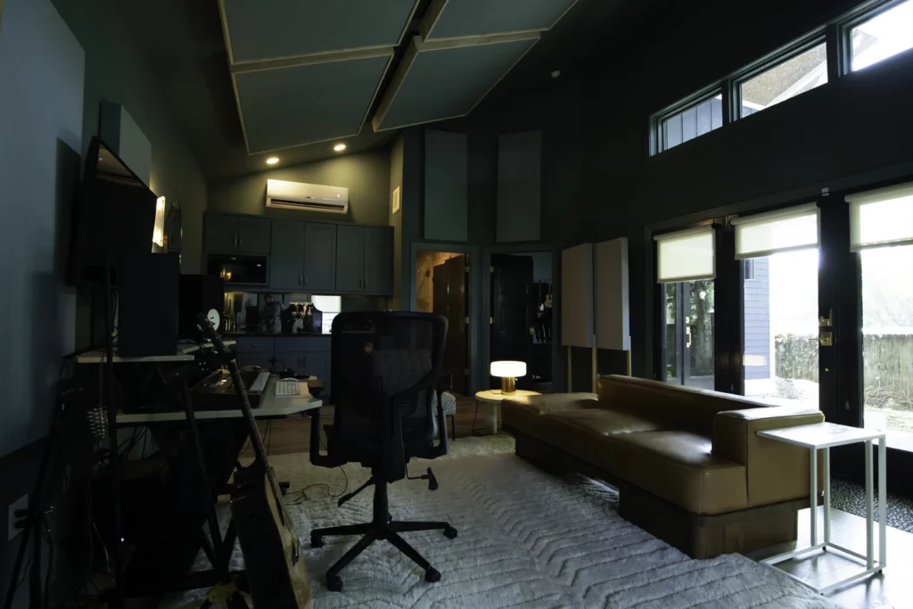 Living room and kitchen in Nashville DADU with vaulted ceilings and windows in blue green with brass accents