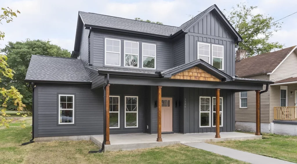 Custom built home with gray and wood exterior with large windows and front porch